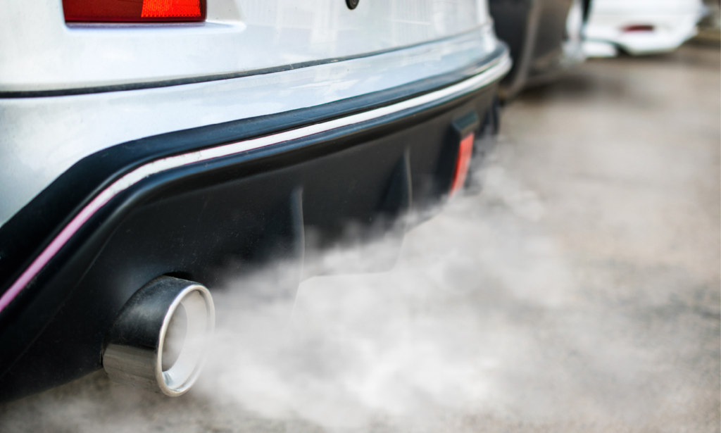 En bil med utsläppsrör som sprider rök. (AI text)