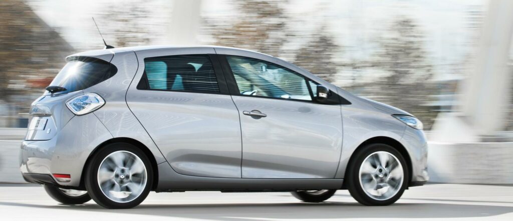 En silver Renault Ion kör nerför en stadsgata. (AI text)