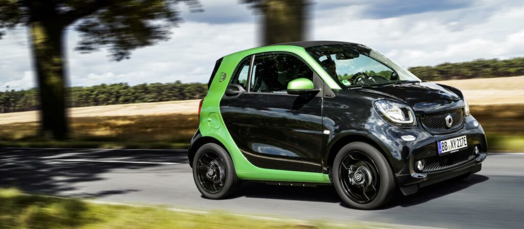 En smart fortwo kör nedför en landsväg. (AI text)