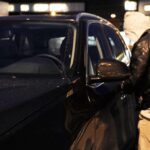 En man låser in sin bil i garaget på natten. (AI text)