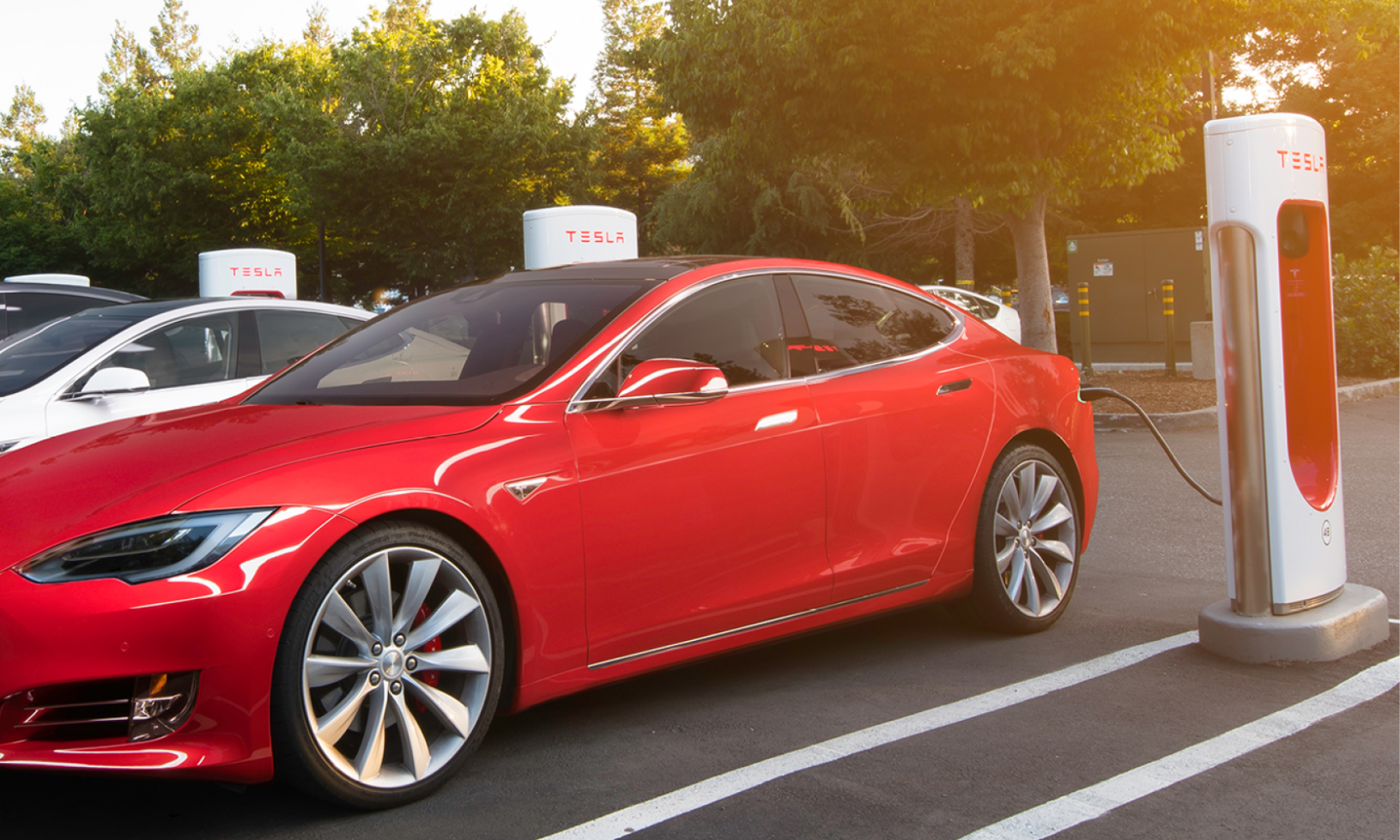 Tesla Model S står parkerad vid en elbilsladdstation. (AI text)