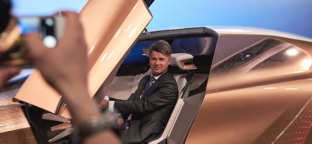 En man tar en bild av en bil. (AI text)