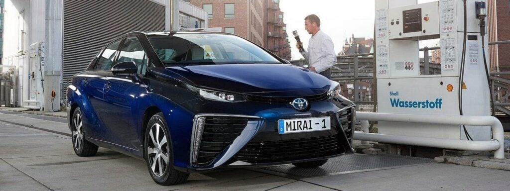 En Toyota Ioniq elbil parkerad framför en laddstation. (AI text)