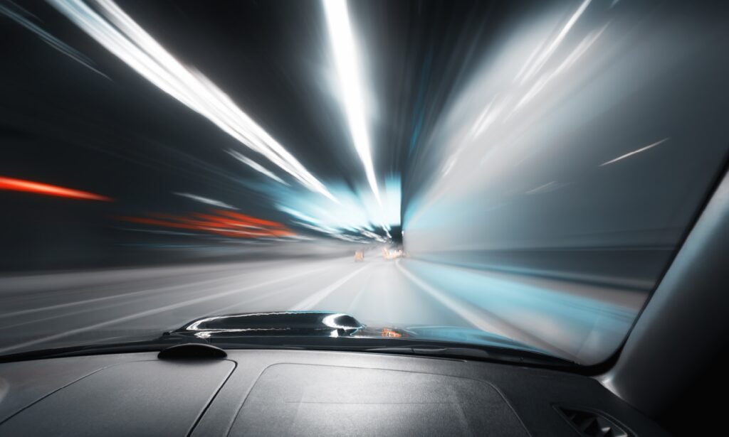 en bil kör nedför en motorväg på natten (AI text)