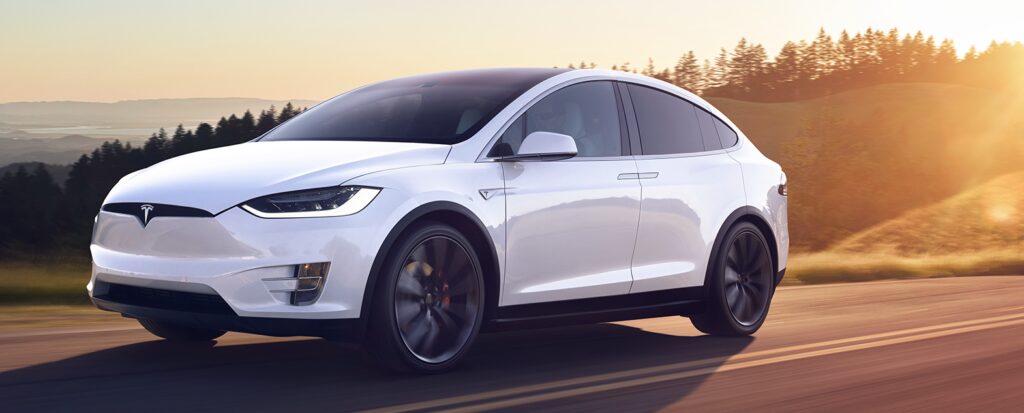 Tesla Model X kör på en landsväg. (AI text)