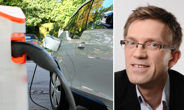 En man står bredvid en bil som laddas vid en elbilstation. (AI text)