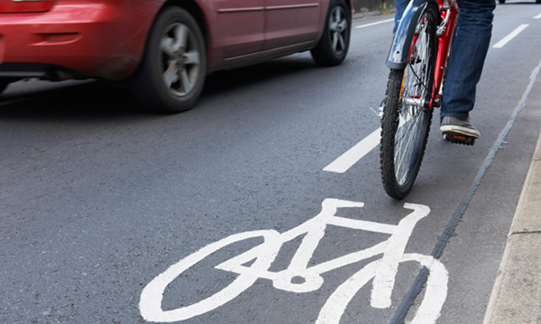 En cyklare kör ner en gata med en cykelbana. (AI text)