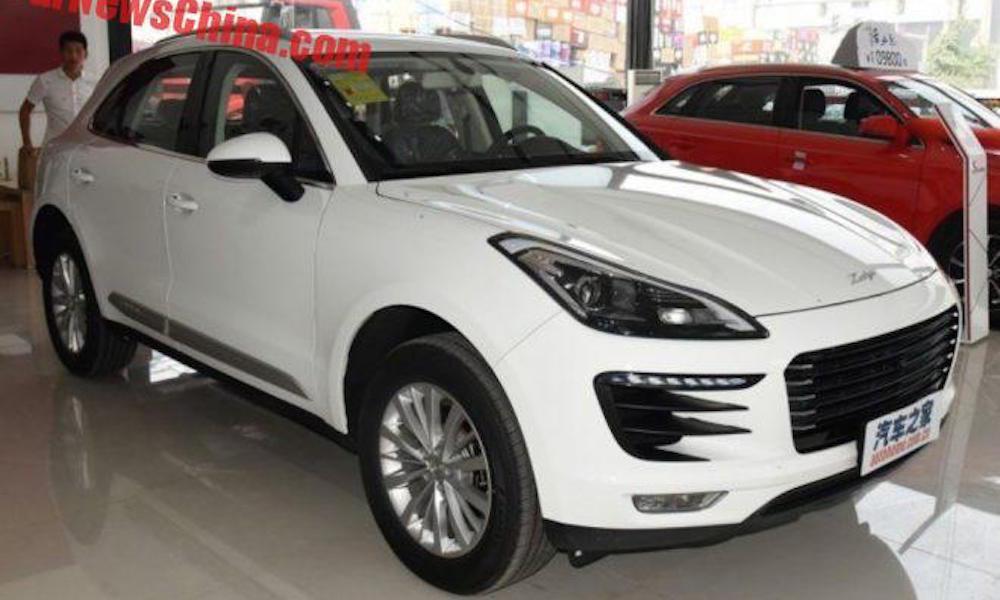 En vit Porsche Cayenne parkerad i en showrum. (AI text)