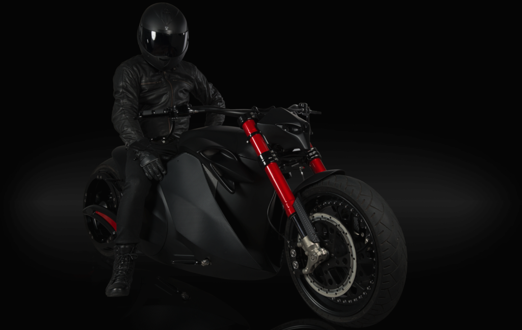 En person kör en motorcykel på en mörk bakgrund. (AI text)