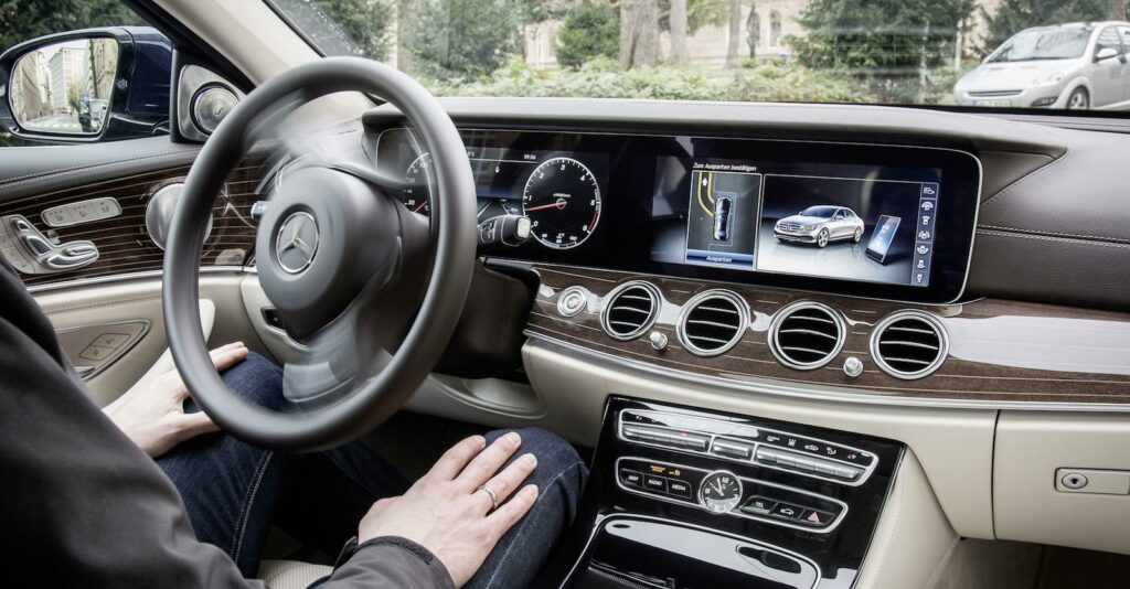 En kvinna sitter i förarsätet av en Mercedes-Benz E-klass. (AI text)