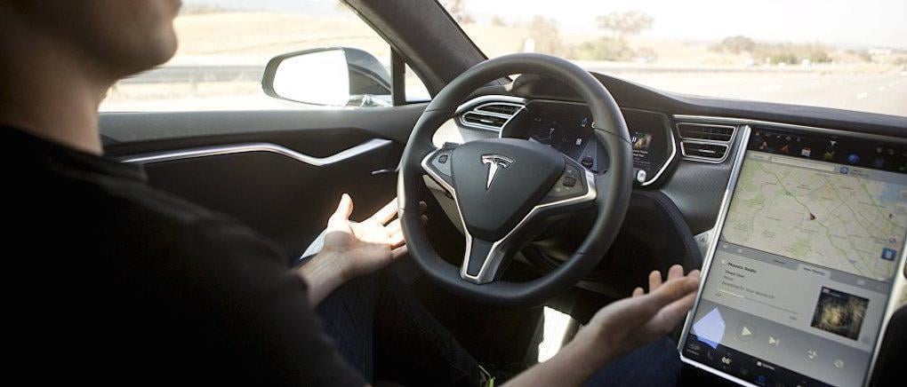 En man kör en Tesla Model S och har en surfplatta monterad i instrumentbrädet. (AI text)