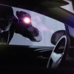 En man sitter i förarsätet i en bil. (AI text)