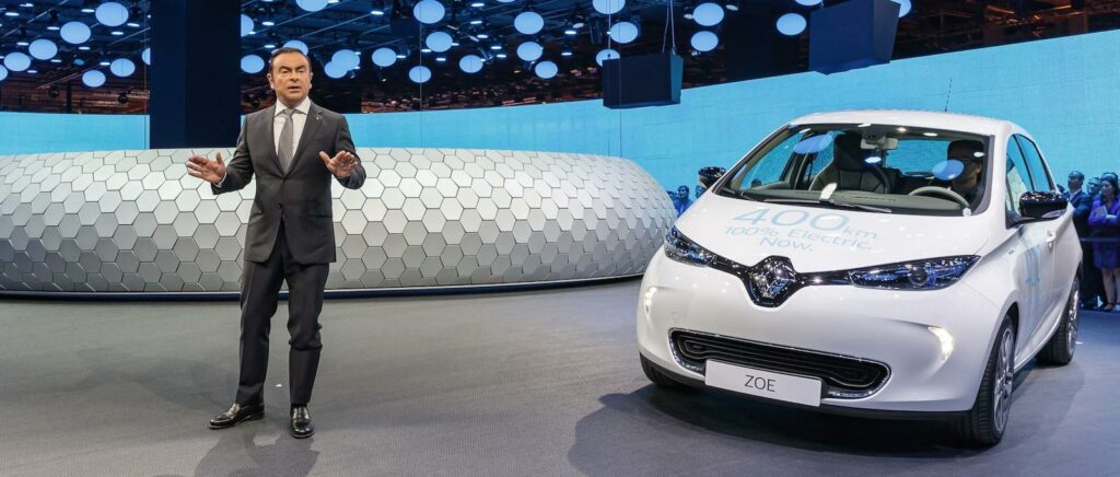 En man i kostym står bredvid en bil. (AI text)