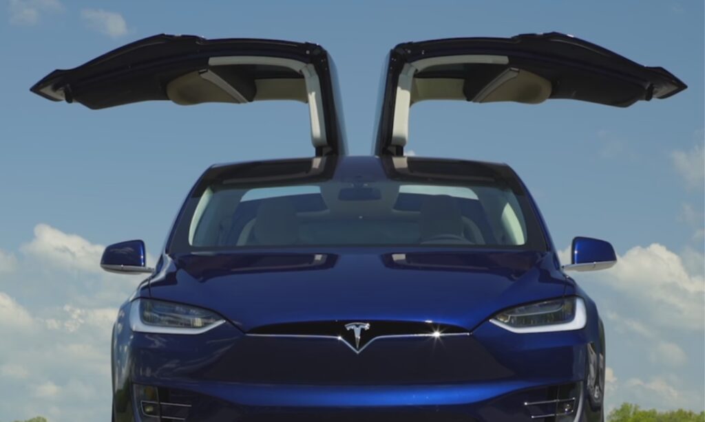 Tesla Model X står parkerad vid vägens kant. (AI text)