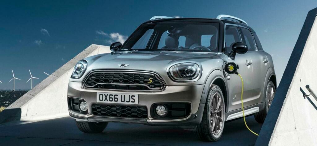 Mini Countryman står parkerad bredvid en vindkraftverk (AI text)