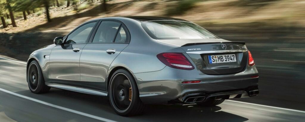 Mercedes C-klass sedan kör nedför en landsväg. (AI text)