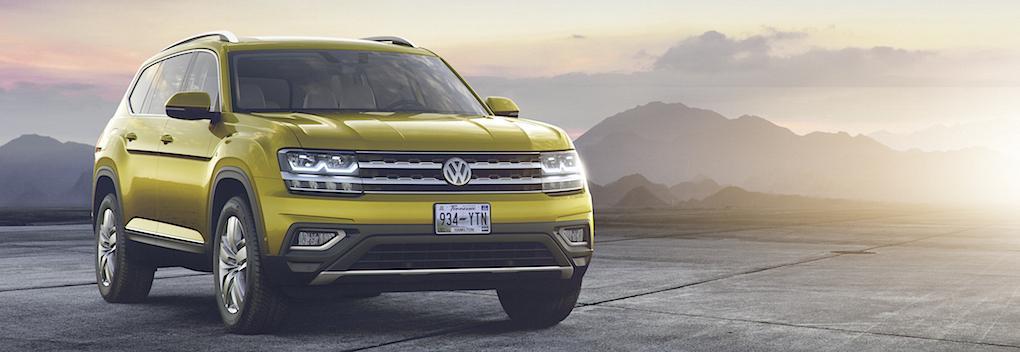 En gul Volkswagen Atlas-terrängbil parkerad på en väg. (AI text)