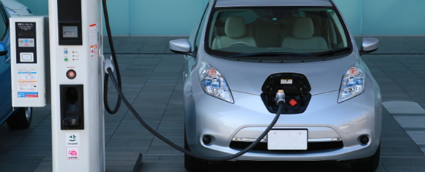 En Nissan elbil laddar på en laddstation. (AI text)