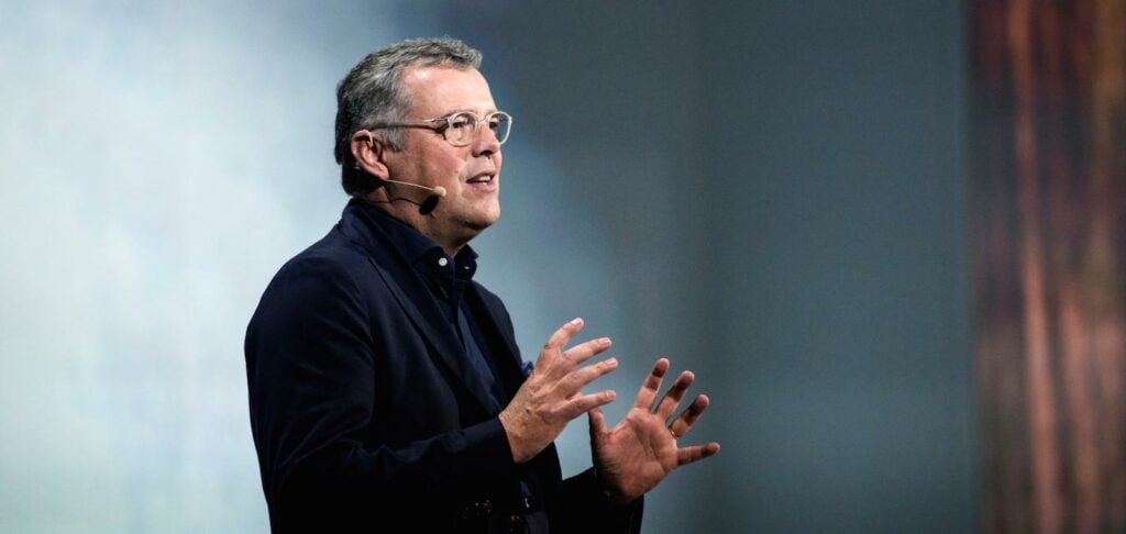 En man håller en föreläsning på en konferens. (AI text)