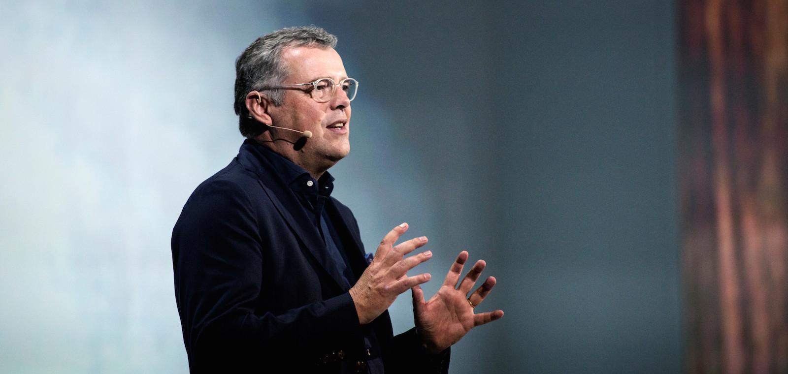 En man håller en föreläsning på en konferens. (AI text)