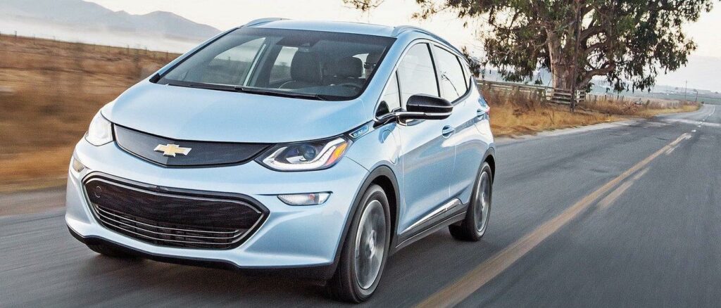 En Chevrolet Bolt EV kör nerför en landsväg. (AI text)