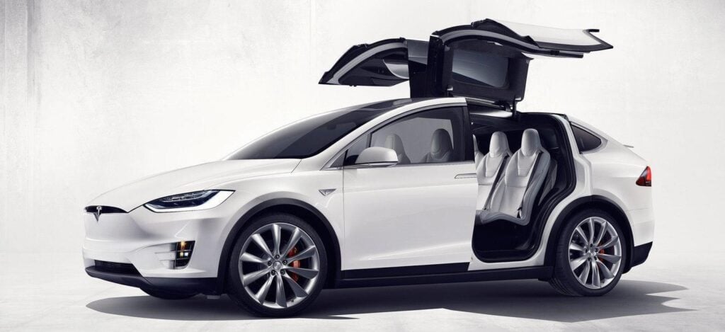 Tesla Model X SUV med öppna dörren. (AI text)