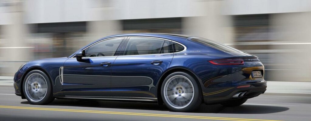 En blå Porsche Panamera kör längs en stadsgata. (AI text)