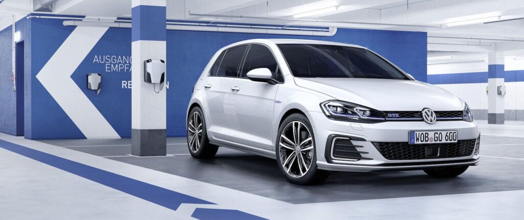 En vit Volkswagen Golf GTI parkerad i en garage. (AI text)