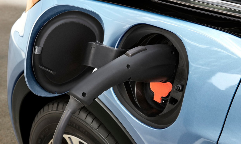 En blå elbil är uppladdad i en elladdare. (AI text)