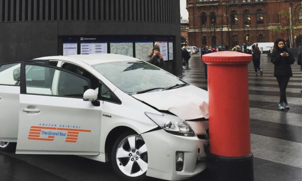 En Toyota Prius står parkerad framför en röd brevlåda. (AI text)