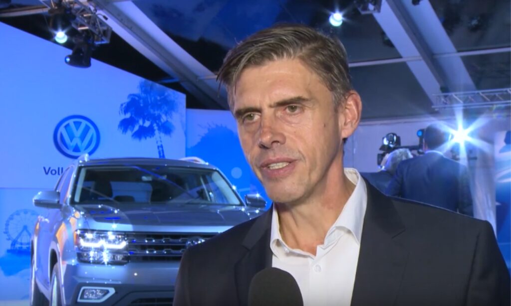 En man i kostym pratar med en reporter. (AI text)