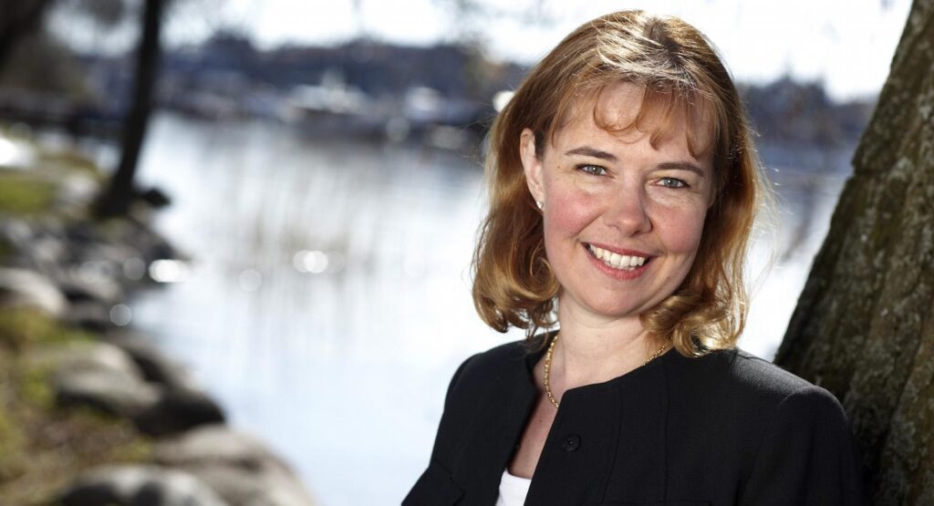 En kvinna lutar sig mot en trädkropp. (AI text)