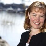 En kvinna lutar sig mot en trädkropp. (AI text)