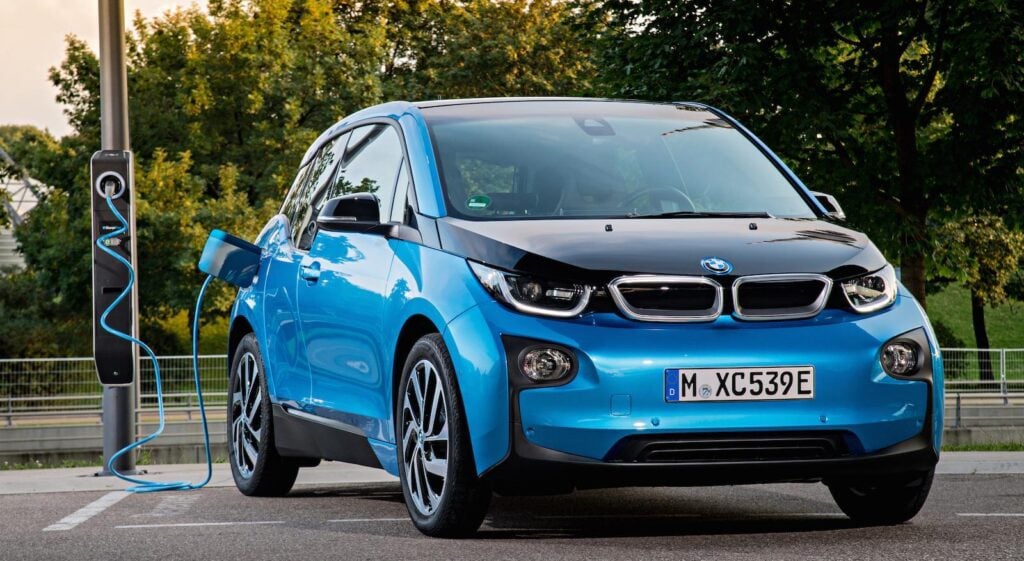 BMW I3 laddar på en laddstation. (AI text)