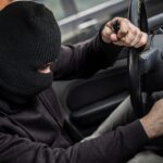 En man i mask klär sig av med en bil. (AI text)