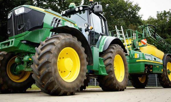 En grön traktor med ett gult cab och en gult traktor. (AI text)