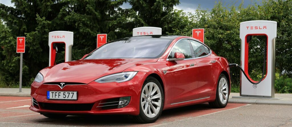 En Tesla Model S parkerad vid en elbilsladdstation. (AI text)