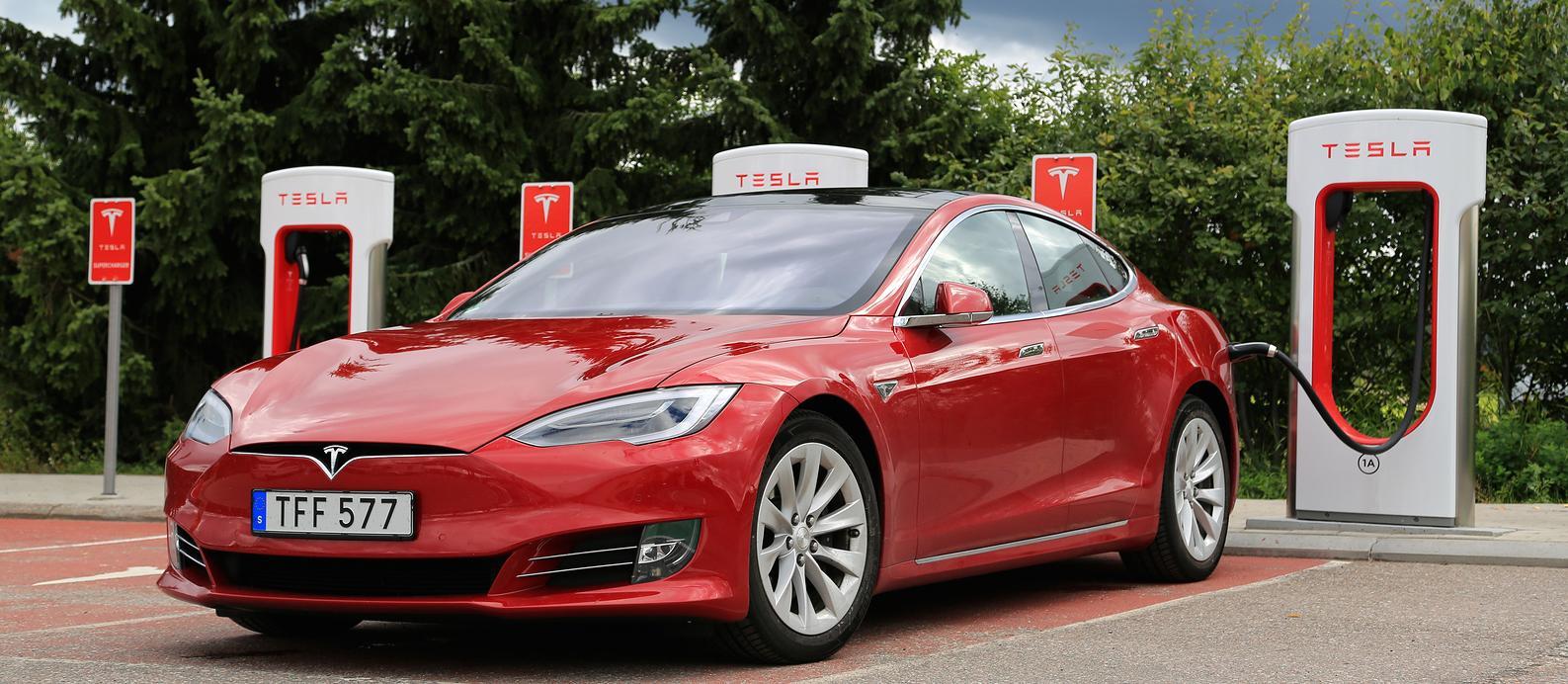 En Tesla Model S parkerad vid en elbilsladdstation. (AI text)