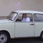 En man kör en liten bil. (AI text)