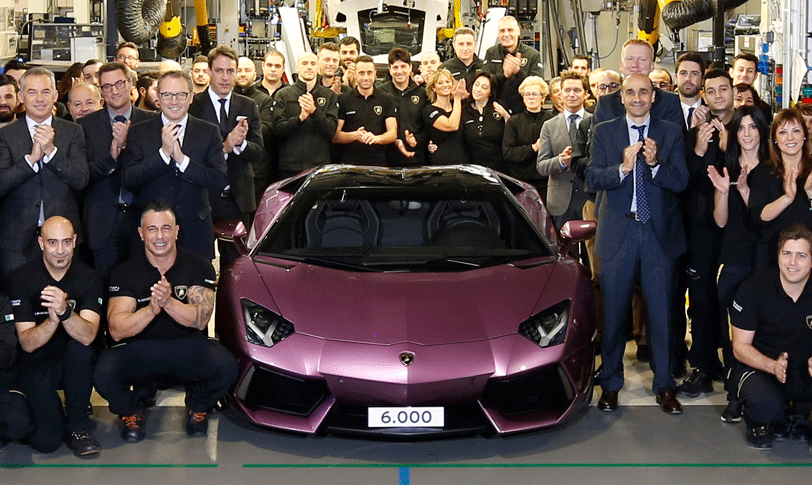 En grupp människor poserar för en bild tillsammans med en Lamborghini. (AI text)