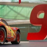 En röd bil visas upp i ett byggnad. (AI text)