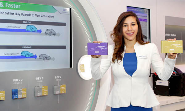 En kvinna håller upp en betalkortsficka framför en stor skärm. (AI text)