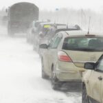 En bil står parkerad på en snöig väg. (AI text)