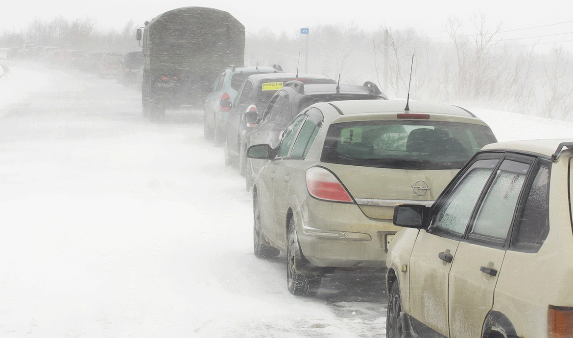 En bil står parkerad på en snöig väg. (AI text)