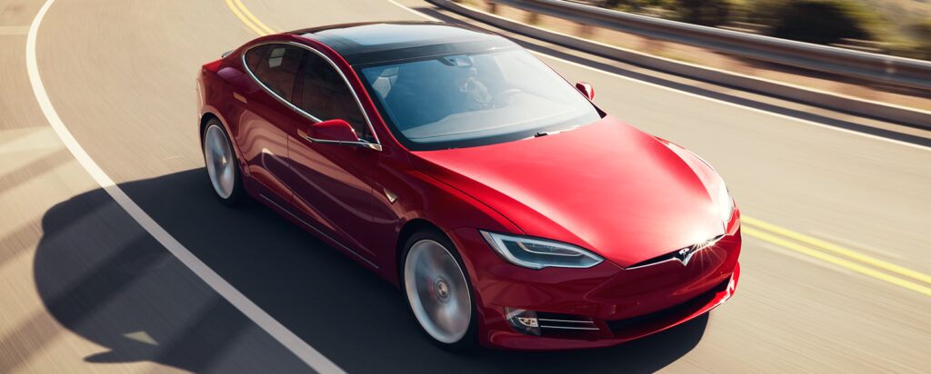 En Tesla Model S kör på en motorväg. (AI text)