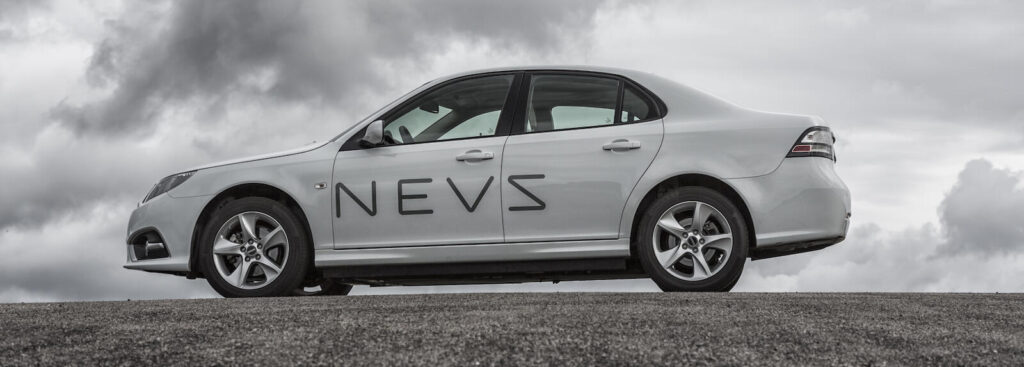 En bil parkerad på en backe med moln i bakgrunden. (AI text)