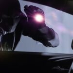 En man kör en bil med en ficklampa i bakluckan. (AI text)