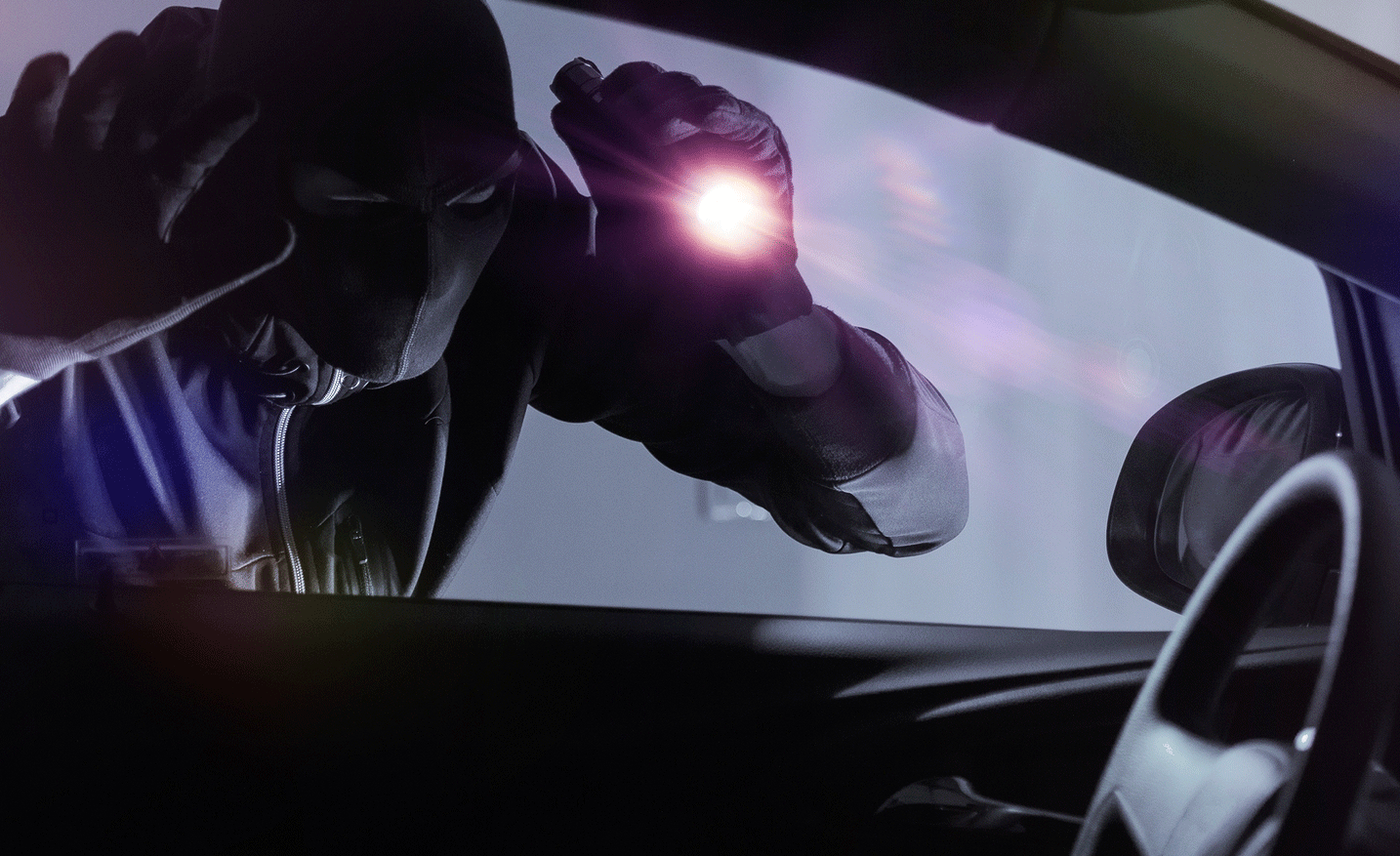 En man kör en bil med en ficklampa i bakluckan. (AI text)