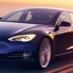 En Tesla Model S kör på en landsväg under solnedgången. (AI text)