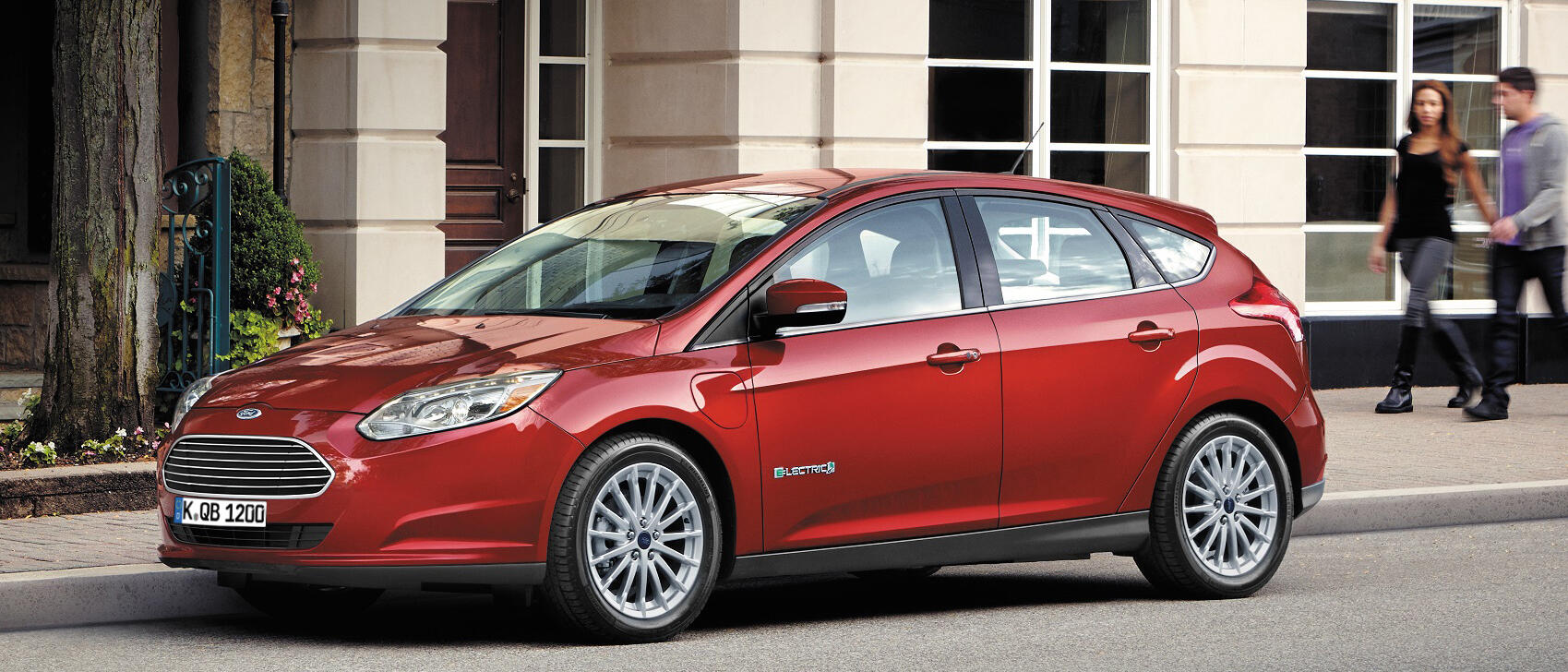 En röd Ford Fusion parkerad framför ett byggnad. (AI text)